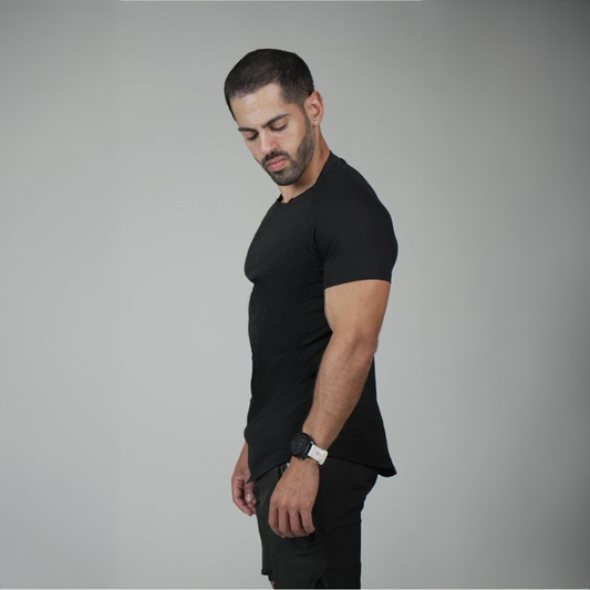 גבר עם שיער קצוץ עם פוזה מהצד לובש חולצה שחורה סקיני על הגוף